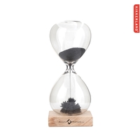 Strikingly clear hourglass is filled with ferrous sand and rests on... from...